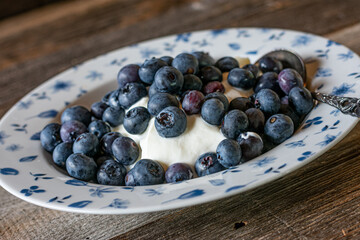 Skyr with fresh blueberries isolated on wooden table