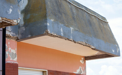 Wall with cracked concrete and rusty irons requiring renovation.