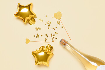 Bottle of champagne, balloons and confetti on color background
