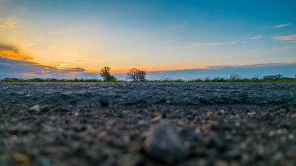 Extreme low angle sunset in dramatic sky over asphalt road. High quality photo
