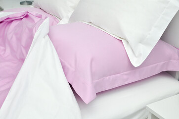 Bed in the hotel covered with pink linens