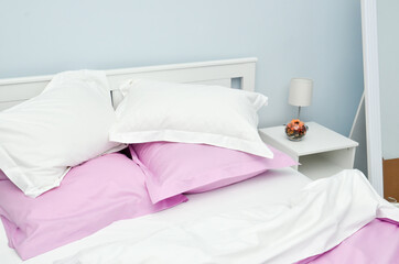 Bed in the hotel covered with pink linens