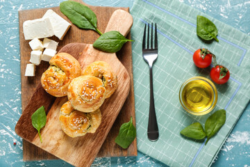 Puff pastry stuffed with spinach, feta cheese and vegetables on color background