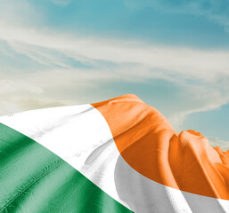 Ireland national flag waving in beautiful clouds.