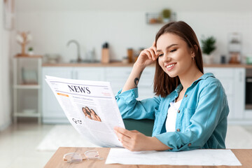 Young woman reading newspaper at home - obrazy, fototapety, plakaty