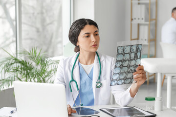 Female doctor studying x-ray scan in clinic