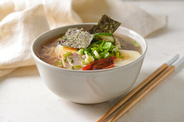 Tasty Chinese soup with chicken in bowl on light background