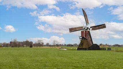 Typical Dutch landscape with two windmills in the countryside near the village of Hoogmade  in the...