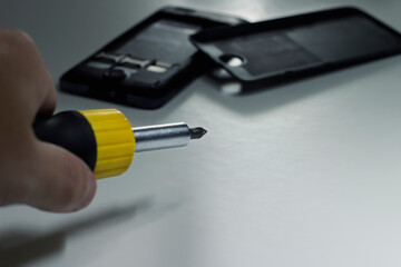 Close-up concept of repairman fixing mobile phone. Disassembled smartphone, electronics repair service