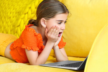 Surprised girl watching cartoons at home