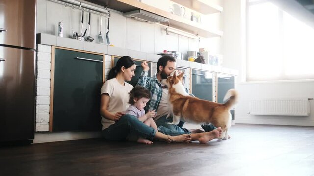 A pleased family spending time together with their dog sitting on the floor