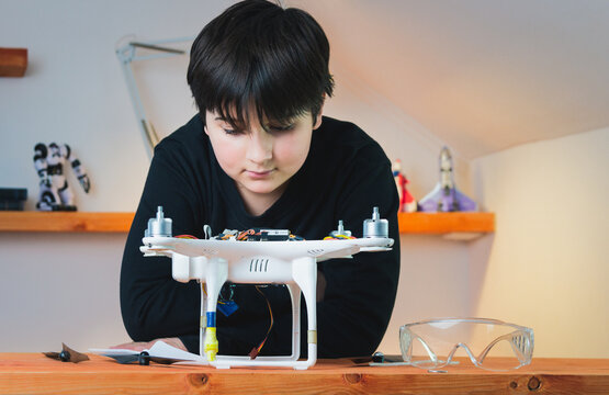 The schoolboy examines the drone he has assembled. Advanced Physics Model. Smart collaboration