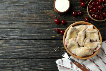 Concept of tasty food with pierogi with cherry on rustic wooden table