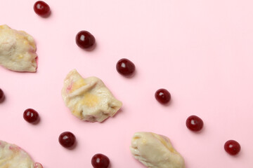 Flat lay with pierogi with cherry on pink background