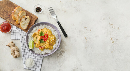 Bowl of tasty chicken curry with rice and ingredients on light background