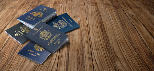 Caribbean passports, Dominica, Saint Kitts and Nevis, Grenada, Saint Lucia, Antigua and Barbuda
on wooden background  - obrazy, fototapety, plakaty