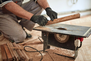 Repairman restoring old parquet hardwood floor.