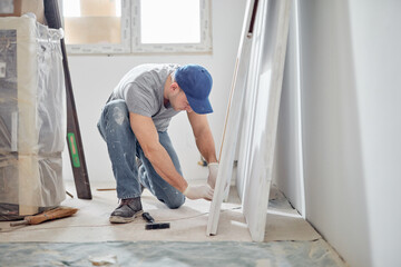 Young adult man working on a DIY budget renovation of his new home apartment.