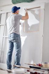 Young adult man working on a DIY budget renovation of his new home apartment.