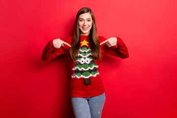 Photo of young positive woman point finger sweater funny christmas holiday isolated on red color background