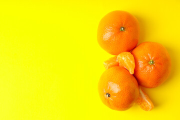 Tasty fresh mandarins on yellow background, space for text