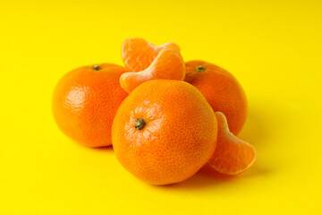 Tasty fresh mandarins on yellow background, close up