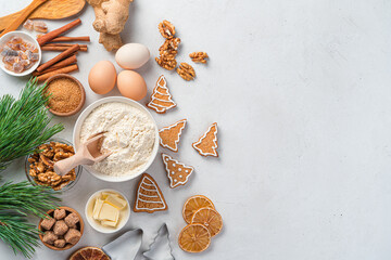 Christmas cooking background with baking ingredients and ginger cookies on a gray background. Happy New Year. Top view, copy space.