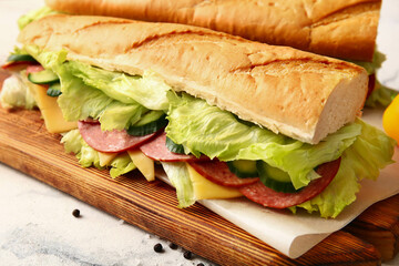 Board with tasty sandwiches on light background, closeup