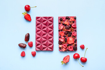 Fototapeta na wymiar Handmade chocolate bars with fruits, berries and nuts on color background