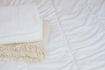 home textiles. A stack of towels lies on a white bed