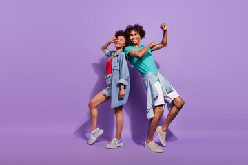 Full length photo of cool happy positive dark skin couple look empty space dance isolated on purple color background