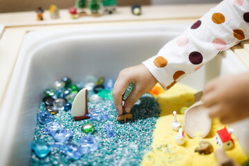 Sensory development box, sea theme with sand and stones, development of fine motor skills in children, close-up toys in touch table