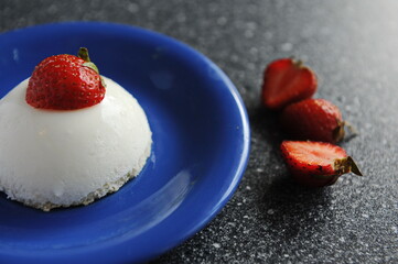 Pudding with strawberries in a plate on the table