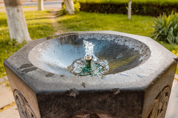 A drinking fountain on the street of the city. Clean water flows from the tap