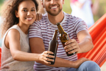 Young couple drinking beer at barbecue party on summer day