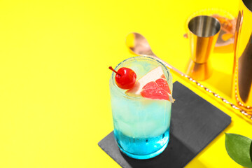 Glass of Blue Lagoon cocktail on color background