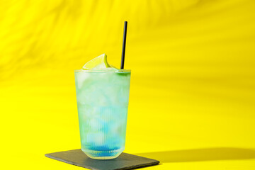 Glass of Blue Lagoon cocktail on color background