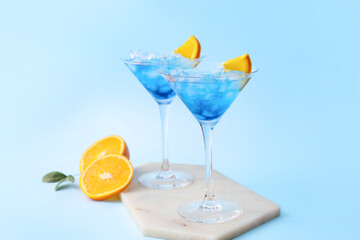 Glasses of Blue Lagoon cocktail on color background