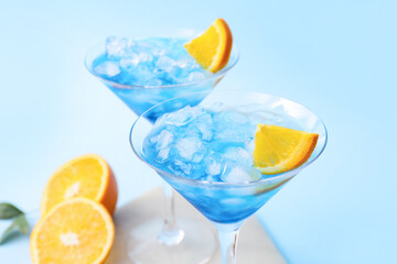 Glasses of Blue Lagoon cocktail on color background