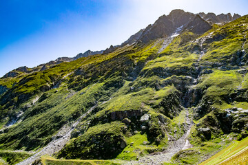 Fototapeta na wymiar Sunny mountain with waterfall in alps