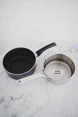 healthy cooking concept, stainless steel vs non stick saucepan side by side with Non Toxic label on the first one