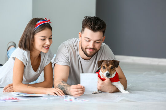 Young couple with cute dog and palette samples planning design of their new house