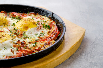 Closeup view of eggs with bell pepper and tomato baked in oven