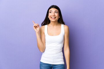 Young brunette woman over isolated purple background intending to realizes the solution while lifting a finger up