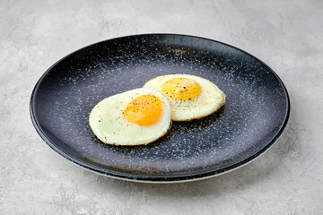 Two fried eggs on a plate.