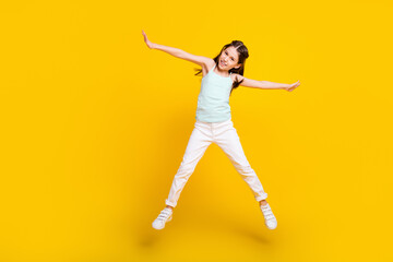 Fototapeta na wymiar Full length body size view of attractive cheerful girl jumping having fun isolated over bright yellow color background