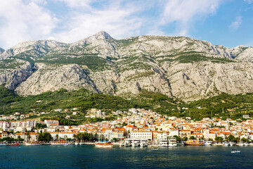 Fototapeta na wymiar Makarska town under mountains, resort on Dalmatian coast of Adriatic sea in Croatia, croatian riviera popular location for vacations