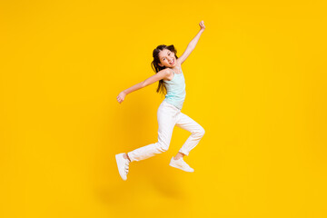 Fototapeta na wymiar Full size profile side photo of cheerful crazy little girl jump up air good mood isolated on bright yellow color background