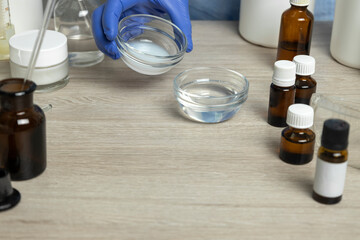 Closeup of laboratory cosmetologist table,lot of bottles full of oils,cosmetics pieces on it.Lab developer mixing beauty ingredients.Free space