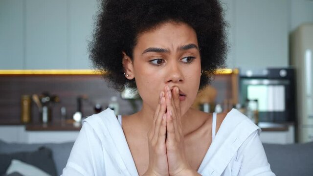 Close-up Of A Young Mixed Race Woman Sitting At The Table With Cup Of Coffee, Looking Around With A Puzzled Look With Concern And Thought. Upset Beautiful African American Woman In Stressful Situation